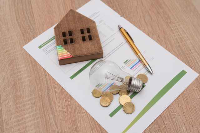 Foto: Glühbirne, Energieskala auf Haus, Münzen